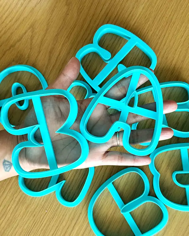 Custom 3D name sign letters in turquoise, held in a hand to show the size